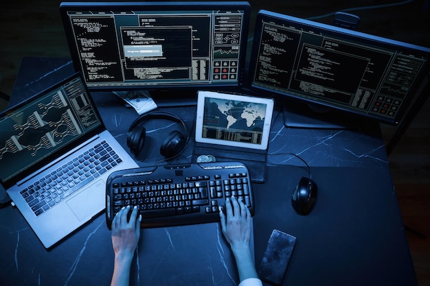 Close up top view of female hacker hands typing on keyboard