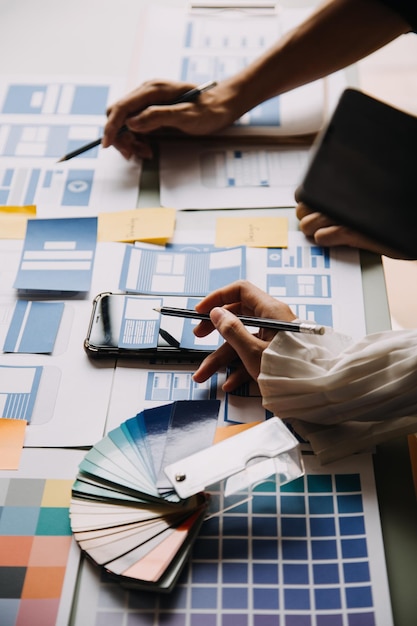 Close up ux developer and ui designer use augmented reality brainstorming about mobile app interface wireframe design on desk at modern officeCreative digital development agency