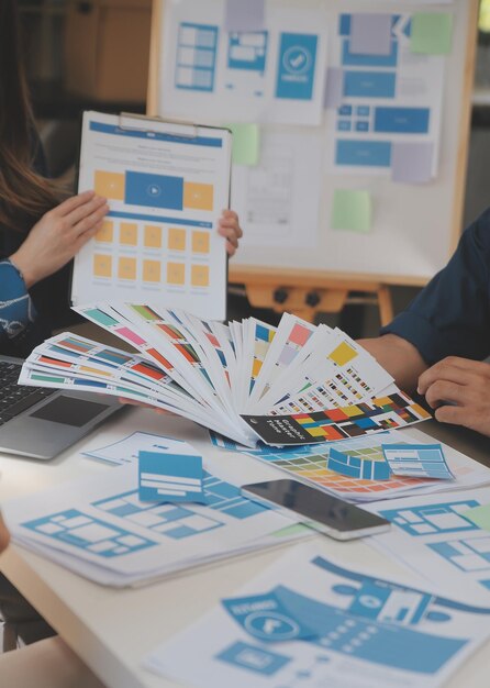 Close up ux developer and ui designer use augmented reality brainstorming about mobile app interface wireframe design on desk at modern officeCreative digital development agency