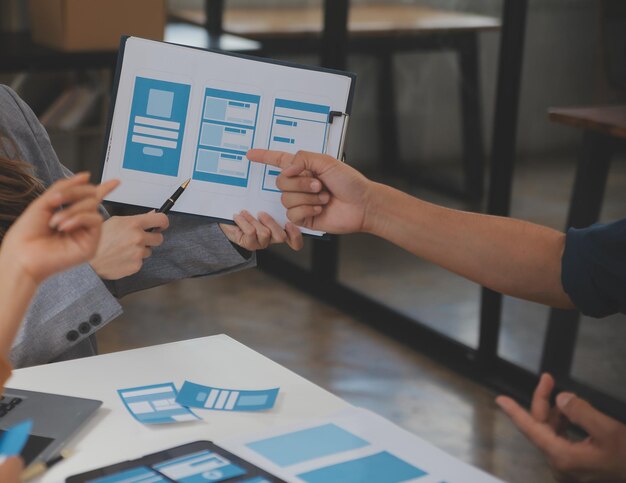 close up ux developer and ui designer use augmented reality brainstorming about mobile app interface wireframe design on desk at modern officecreative digital development agency