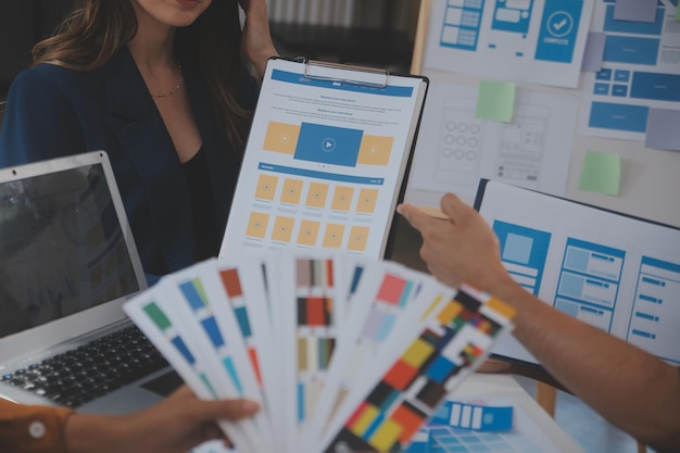 Close up ux developer and ui designer use augmented reality brainstorming about mobile app interface wireframe design on desk at modern officeCreative digital development agency
