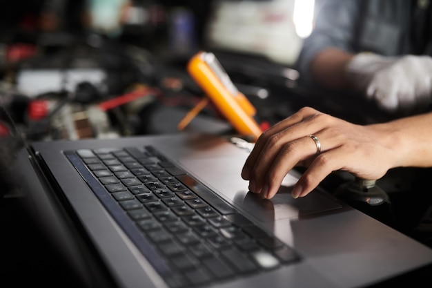Closeup image of mechanic using computer program when checking vehicle systems