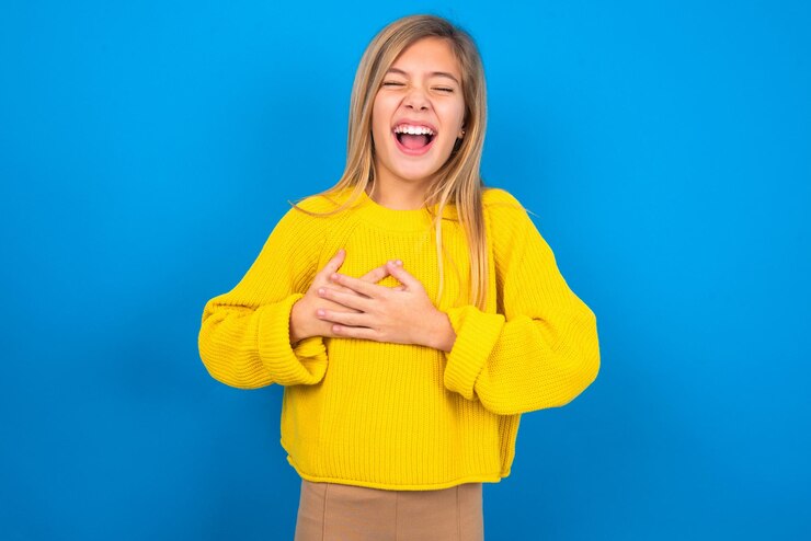 Photo cô gái bày tỏ hạnh phúc cười vui vẻ giữ tay trên tim