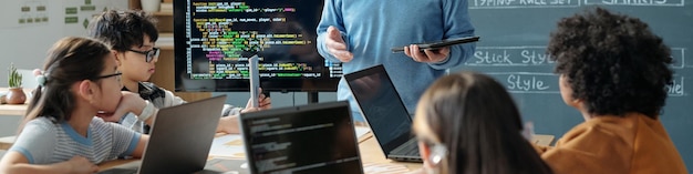 Coding lessons with teacher explaining and students listening