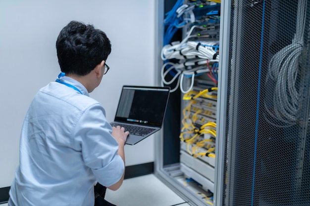 computer engineer is setting up network in server roomsystems maintenance technicianmale engineer working in server room at modern data center