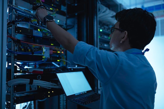 computer engineer is setting up network in server roomsystems maintenance technicianmale engineer working in server room at modern data center