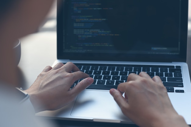 computer programmer software engineer coding javascript on laptop
