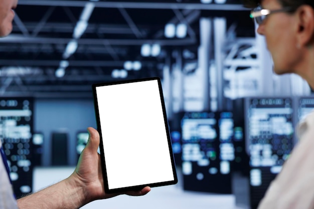 Computer scientists using mock up tablet to check blade servers, close up. Machines in computer network security data storage business providing processing and memory resources for several workloads