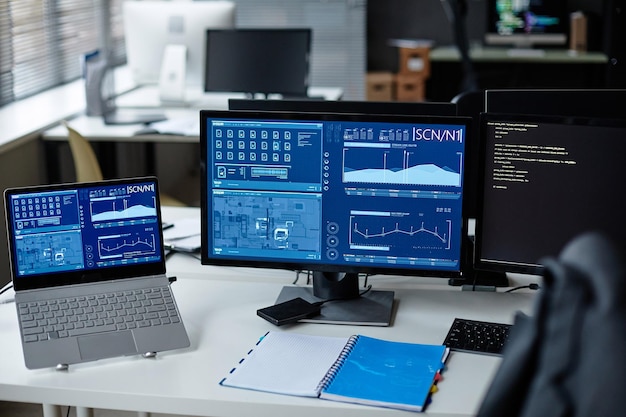 Computers on desk with blue data charts