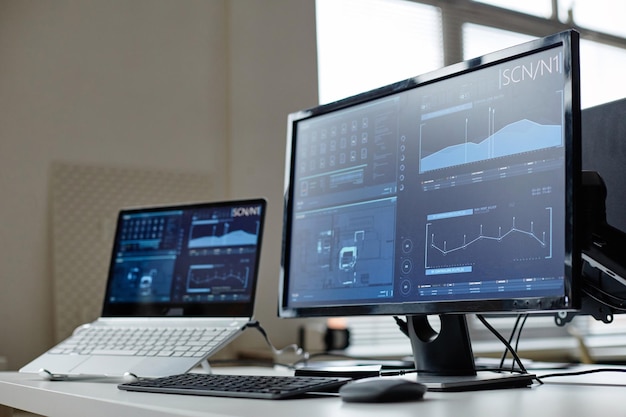 computers on desk with data screens
