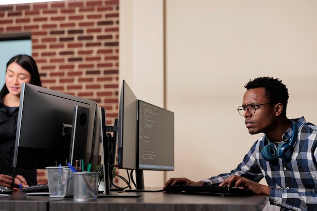 Confused tech engineer sitting doubtful at computer trying to solve network processing errors. Computer programmer puzzled by nonfunctional security algorithm and company corrupted database.