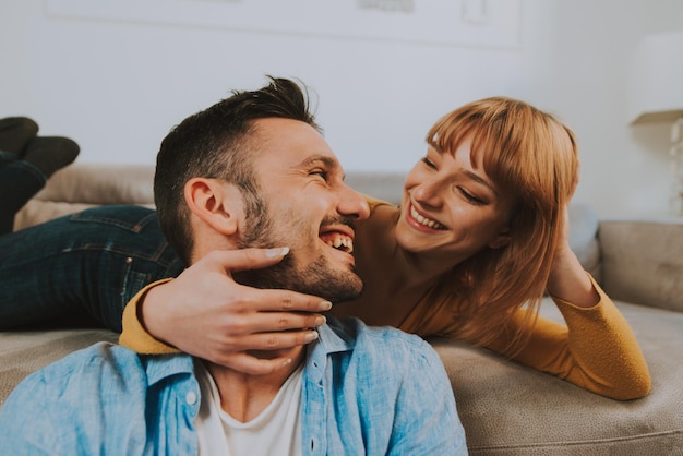 couple embracing while sitting on sofa at home
