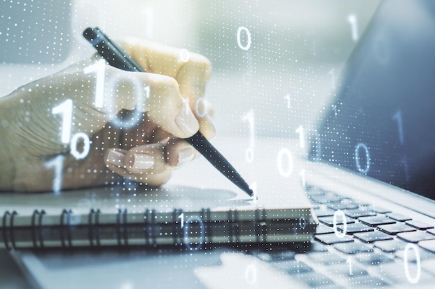 Creative abstract binary code sketch and hand writing in notepad on background with laptop hacking and matrix concept Multiexposure