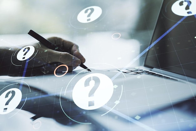 Creative concept of question mark illustration and hand writing in notebook on background with laptop FAQ and search concept Multiexposure