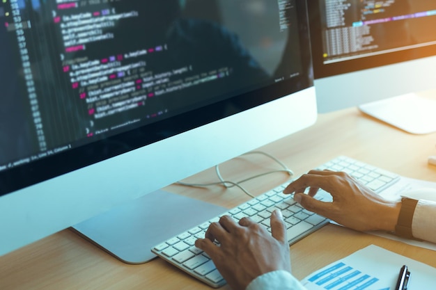 cropped hands of businessman coding on computer in office