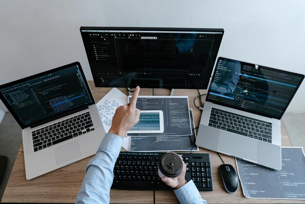 cropped hands of software programmer working on table