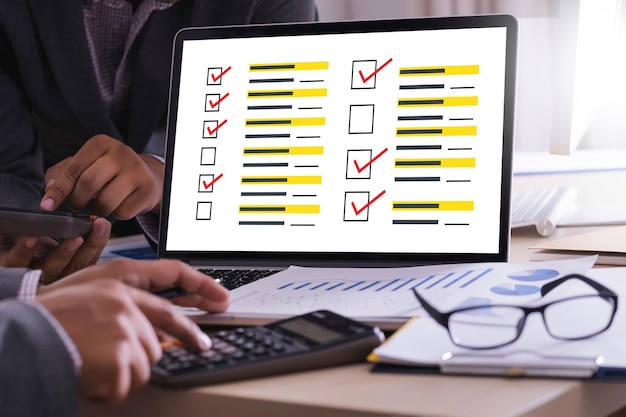 Cropped hands using calculator at table in office