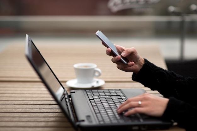 Cropped hands using technologies at desk