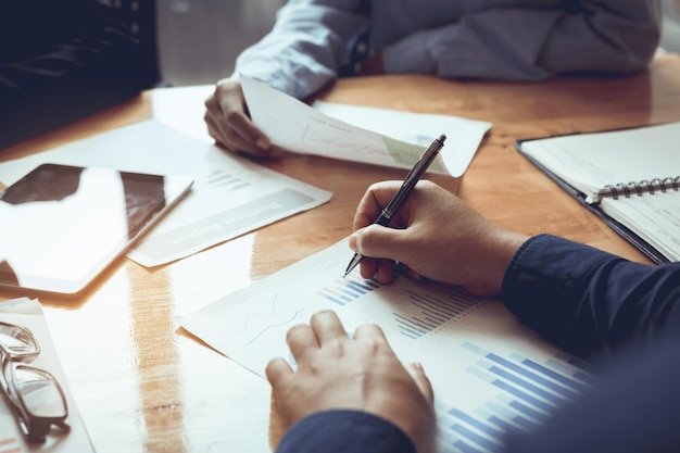 Cropped image of businessmen working over graph in office