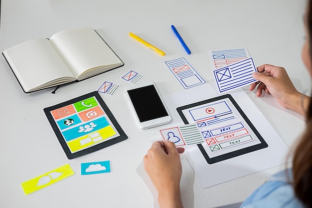 Cropped image of woman holding various paper icons at table