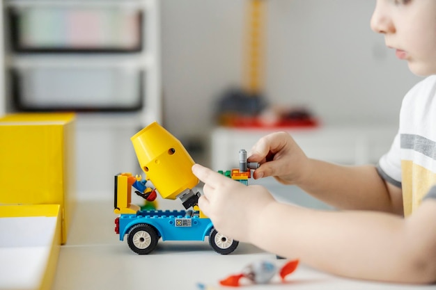 Cropped picture of a boy playing a game with his toys in his room