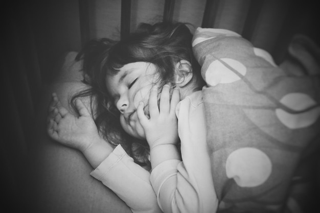 cute girl sleeping on bed at home