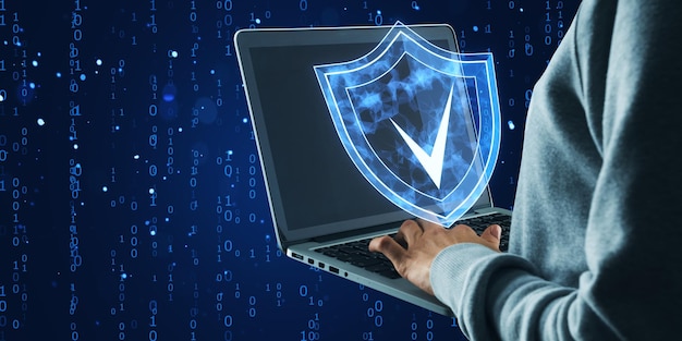 Cyber security concept with shield icon on laptop screen in digital environment