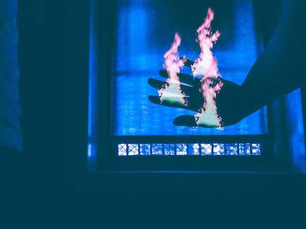 Digital composite of cropped hand set on fire at home