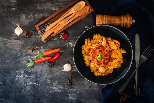 directly above shot of pasta by carrots and eating utensils on table