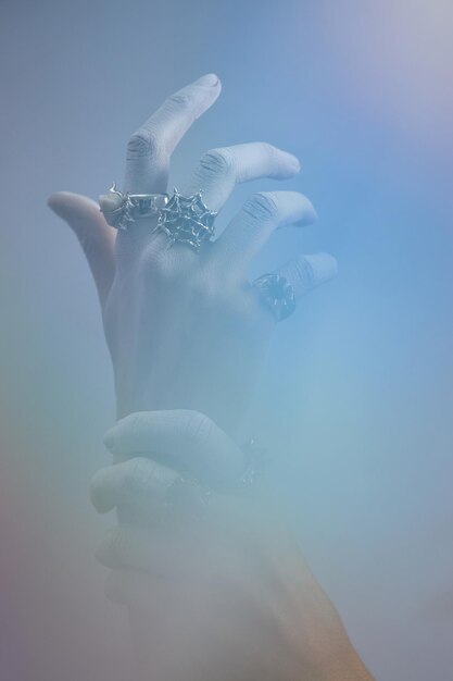 Displaying hand with multiple ornate rings and jewelry