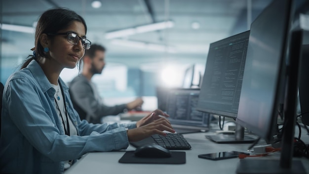 Diverse Office Indian IT Programmer Working on Desktop Computer Female Specialist Creating Innovative Software Engineer Developing App Program Video Game Writing Code in Terminal