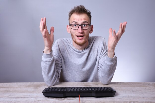 Doanh nhân trẻ mọt sách hài hước đang làm việc trên máy tính