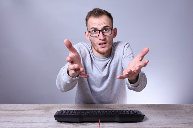 Doanh nhân trẻ mọt sách hài hước, người đàn ông làm việc trên máy tính. Lập trình viên gõ bàn phím đeo kính trước máy tính.