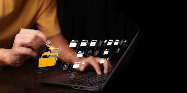 Document Management System DMS being setup by IT consultant working on laptop computer in office with document directory Software for archiving searching and managing corporate file information
