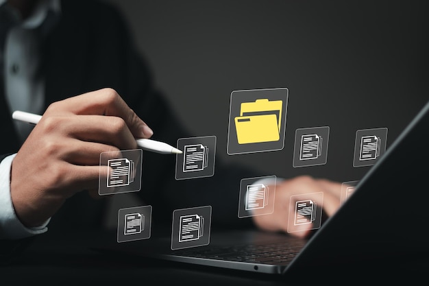 Document management system DMS technology businessman use laptop with database to store files document data digital file storage process with security information technology concept