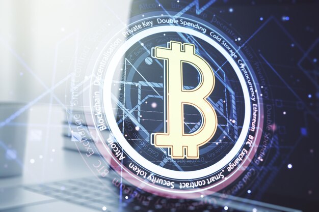 Double exposure of creative Bitcoin symbol with modern laptop on background Cryptocurrency concept