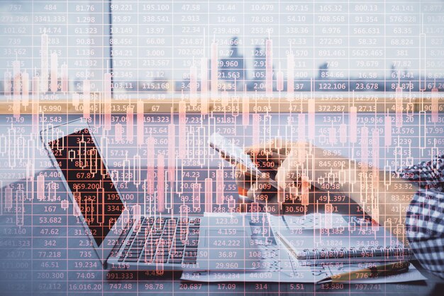 double exposure of mans hands holding and using a digital device and forex graph drawing financial market concept