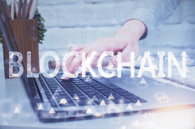 double exposure of woman hands typing on computer and crypto market theme hologram drawing blockchain concept