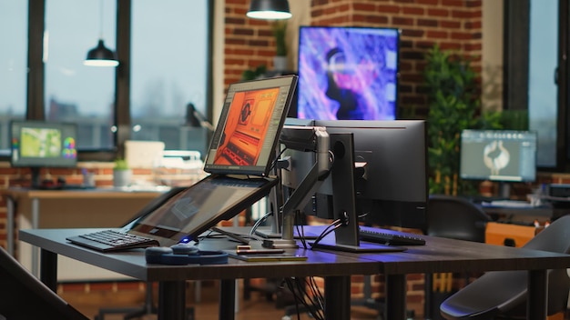 Empty creative agency studio filled with workstations to create content for modern production, running professional softwares. Programming technical prototype or developing game.