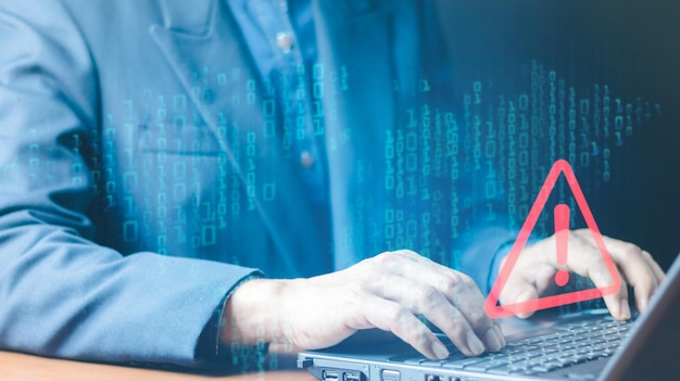 Error and maintenance concept Businessman or it staff programmer developer using computer laptop with triangle caution warning sign for notification