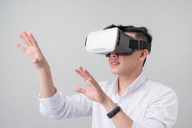 excited asian man in a vr goggles and gesturing with his hands