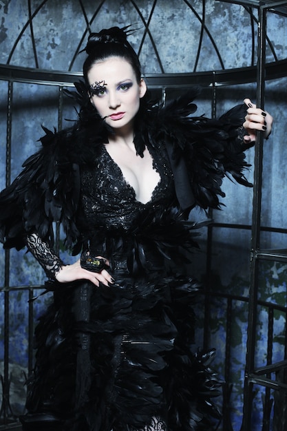fashion model in fantasy dress posing in steel cage.