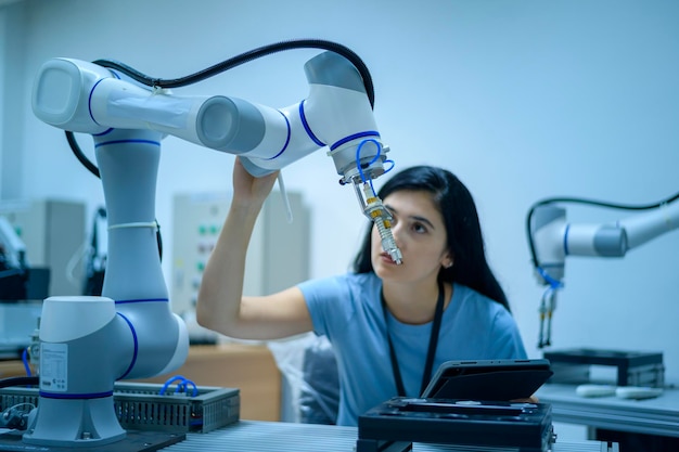 Female Robotics engineer working with Programming and Manipulating Robot Hand