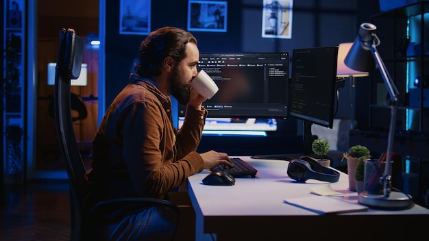 Focused programmer drinking coffee in apartment while solving database errors