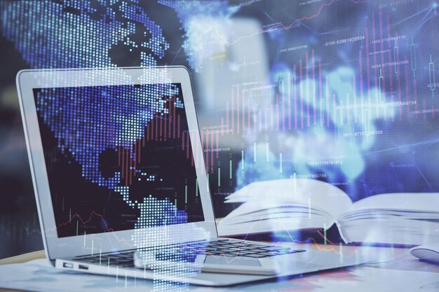 forex graph hologram on table with computer background double exposure concept of financial markets
