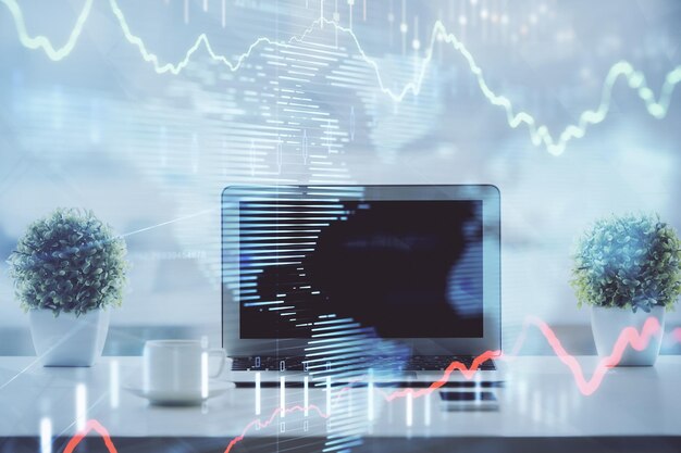 Forex graph hologram on table with computer background Multi exposure Concept of financial markets