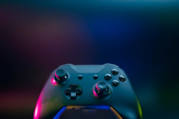 Gamer playing the online game with joystick controller in neon glow dark cyberpunk room gaming and esports challenge tournament streaming streamer with analog device in living house