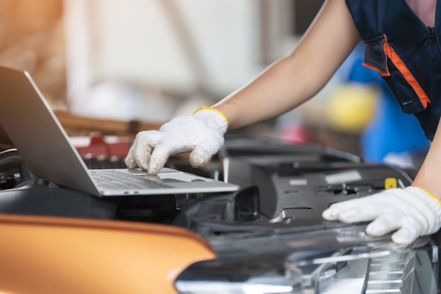 Girl engineer mechanics working on a vehicle in a garage or service wo
