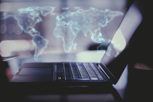 global internet concept with digital world map and laptop with back light effect