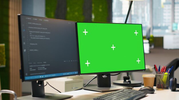 Green screen computer display in modern startup office displaying code snippets in various